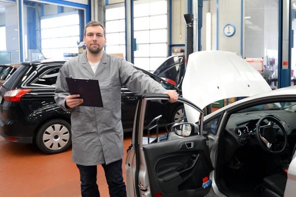 Ein TÜV Prüfer untersucht ein behindertengerechtes Fahrzeug